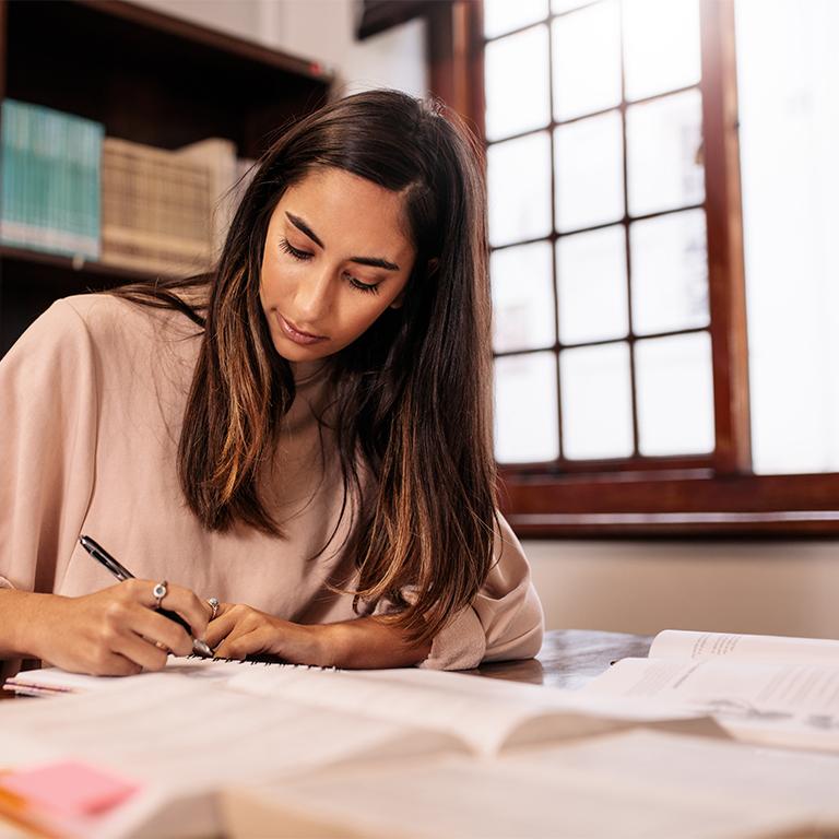 Researchers sitting at desk writing in a notebook