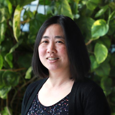 Photograph of Helen Chan standing in front of plants